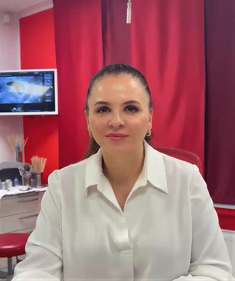 Doctor-medic Gabriela Bankos in weißer Bluse in ihrem Behandlungszimmer